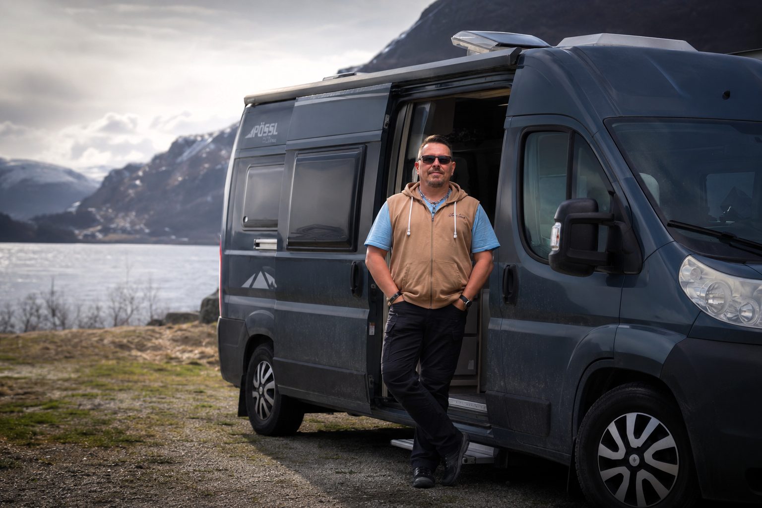 Janne Engman at the open door of the EngmanMedia campervan, parked beside a fjord in the north.